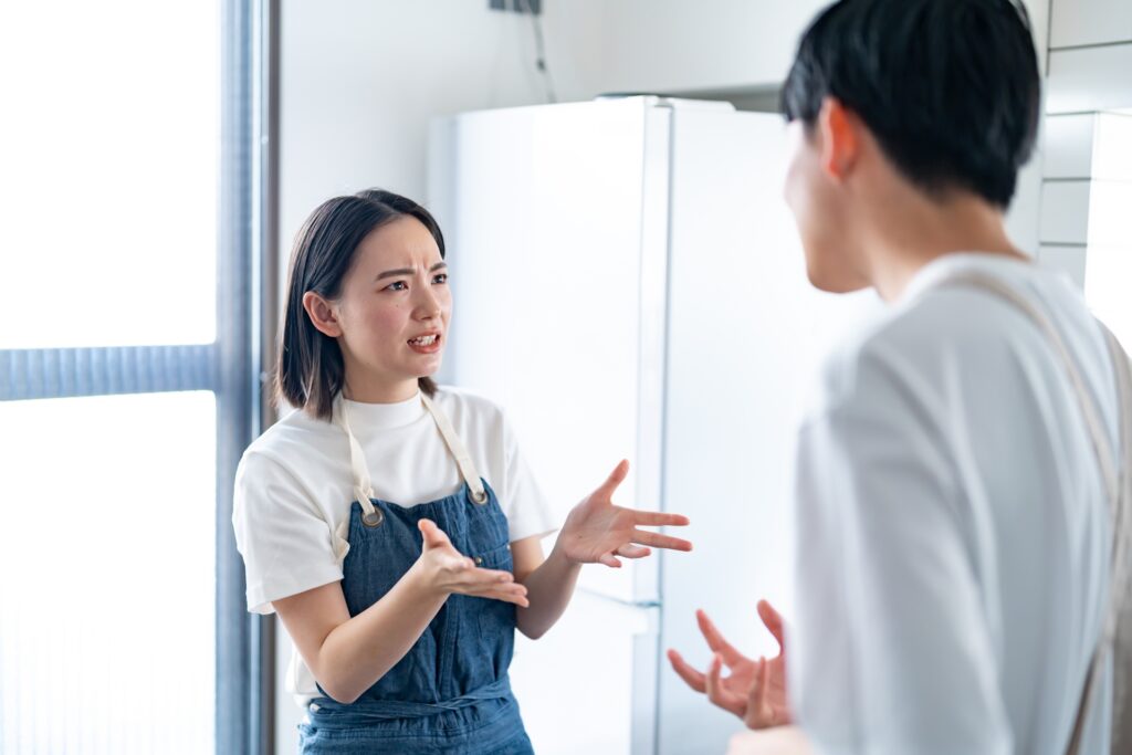 男女が感情的に言い争っている様子の写真